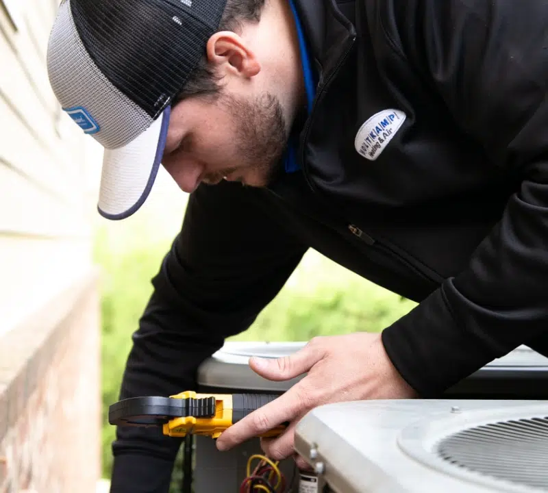 Holtkamp HVAC Tech working on a heating unit 
