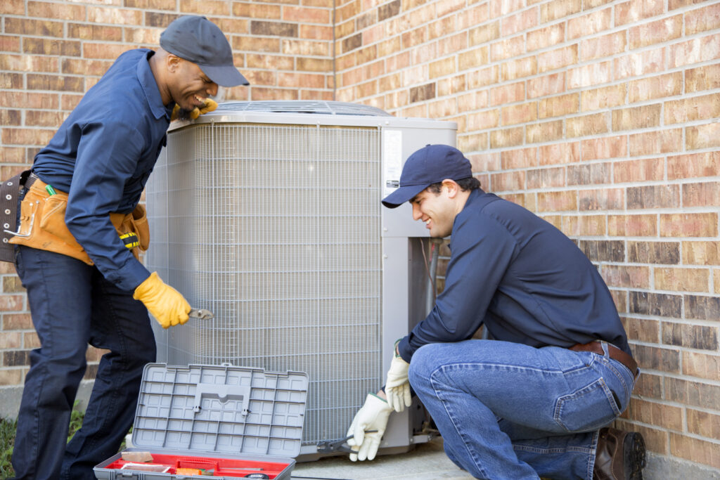 HVAC technicians installing residential condenser unit